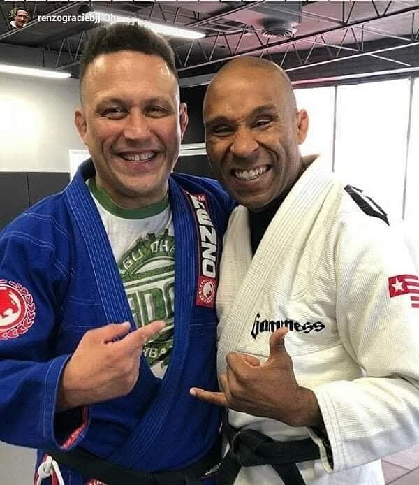 Gideon Ray smiling with Renzo Gracie after training, both in their gis.